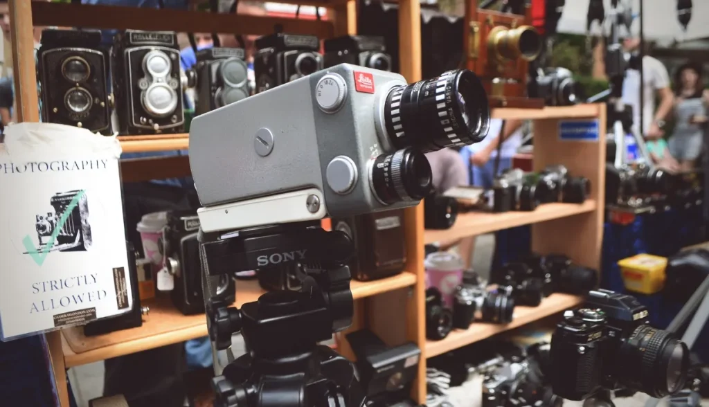 木製の棚に展示されたヴィンテージカメラと最新カメラのコレクション。手前にはライカ(Leica)のカメラが置かれています。